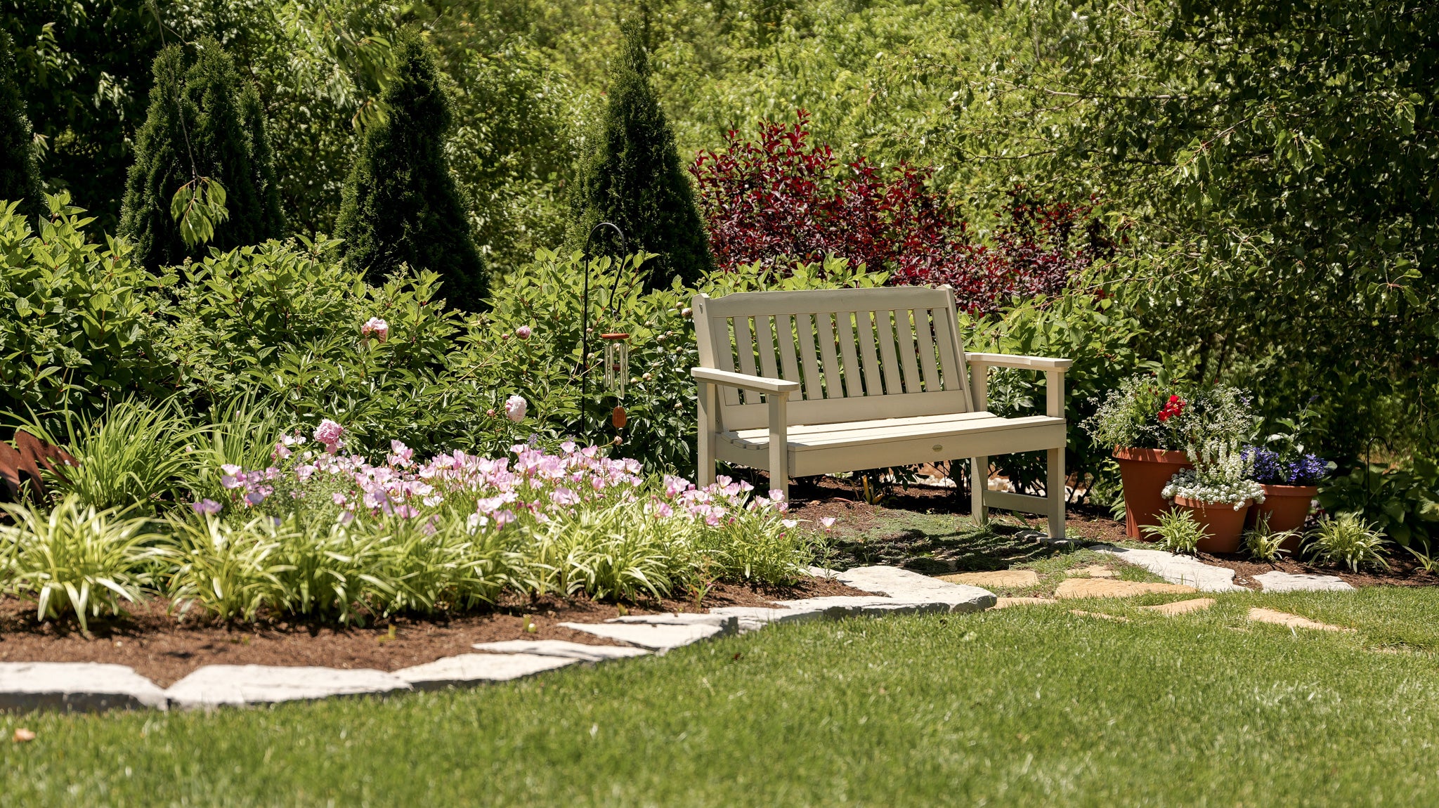 Garden scene with a bench, flowers, and trees